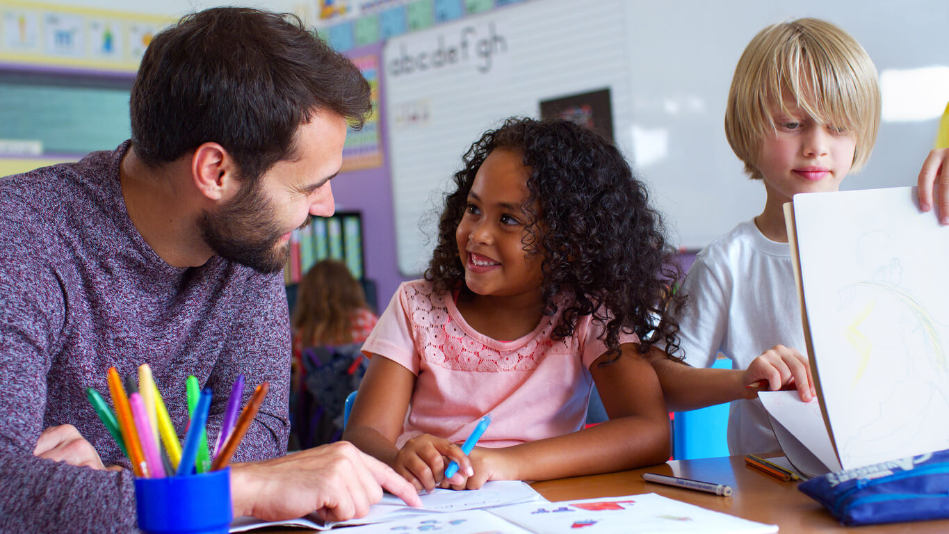 Teacher guiding a small group of young students through a literacy lesson